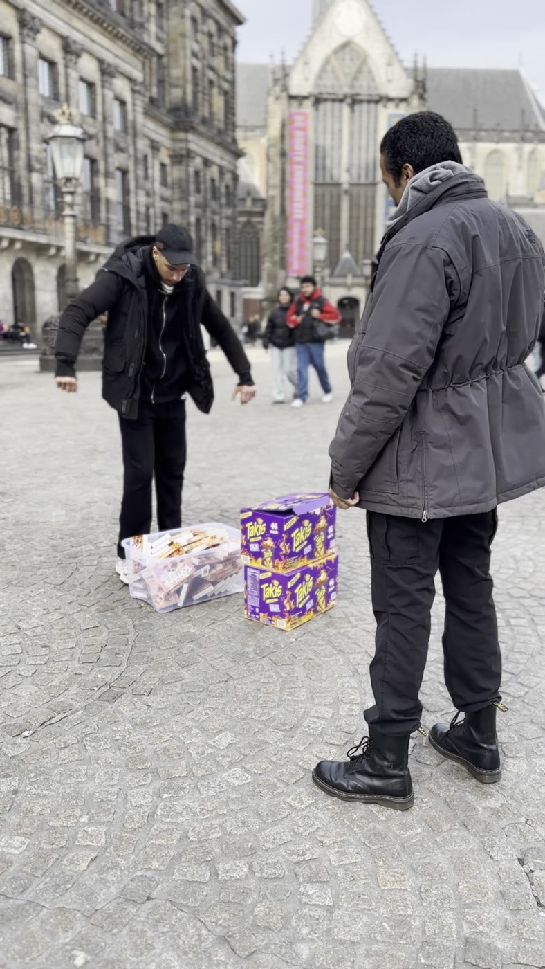 Filming a Candy Bites giveaway on Dam Square, boxes of candy on the cobblestones
