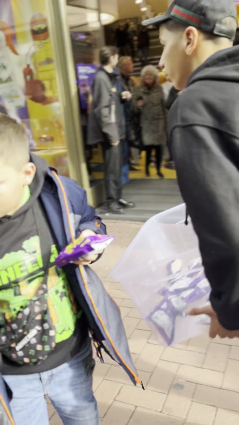 A young passer-by picking a free candy bar from the giveaway box