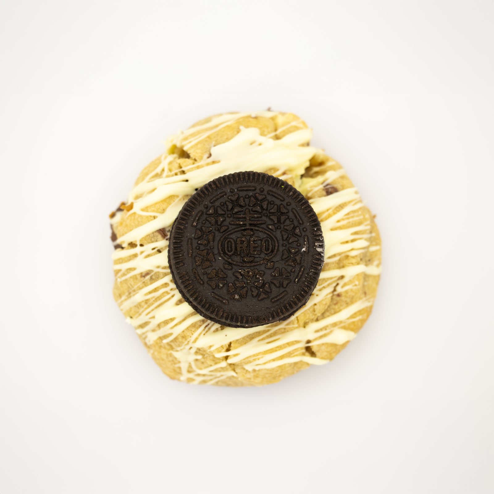 Cookie topped with a whole Oreo and white chocolate, shot from above