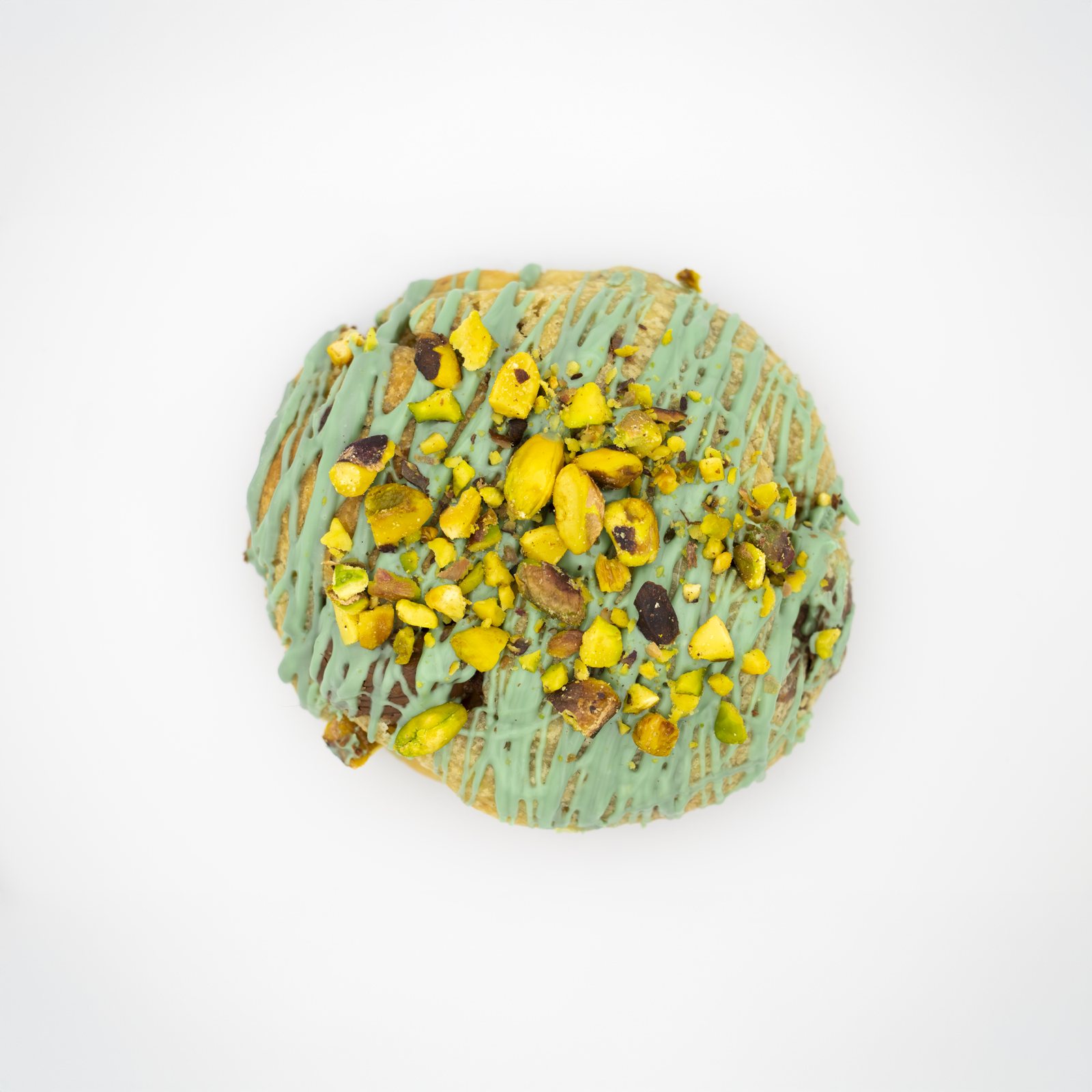Pistachio cookie with crushed nuts and green glaze, shot from above