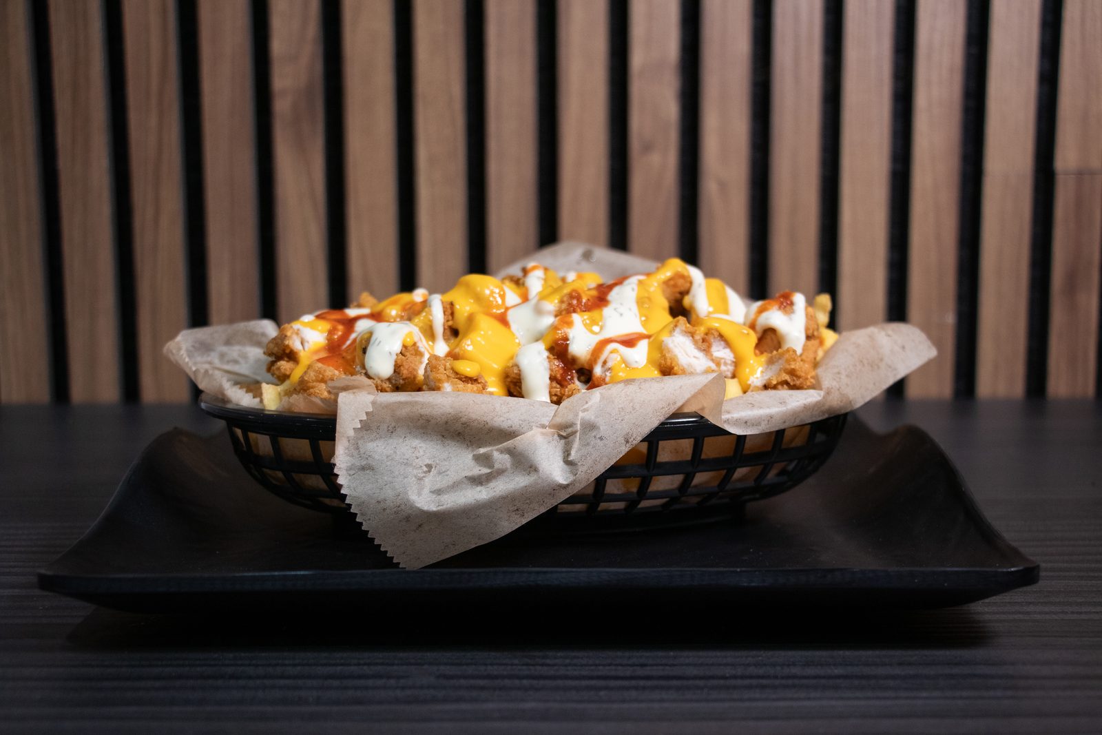 Loaded fries with sauce in a paper-lined basket