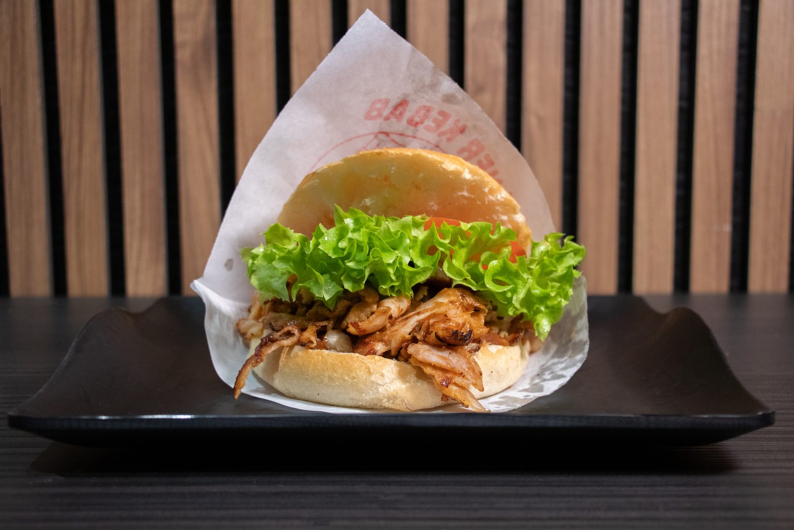 A pulled-chicken burger in a paper wrap