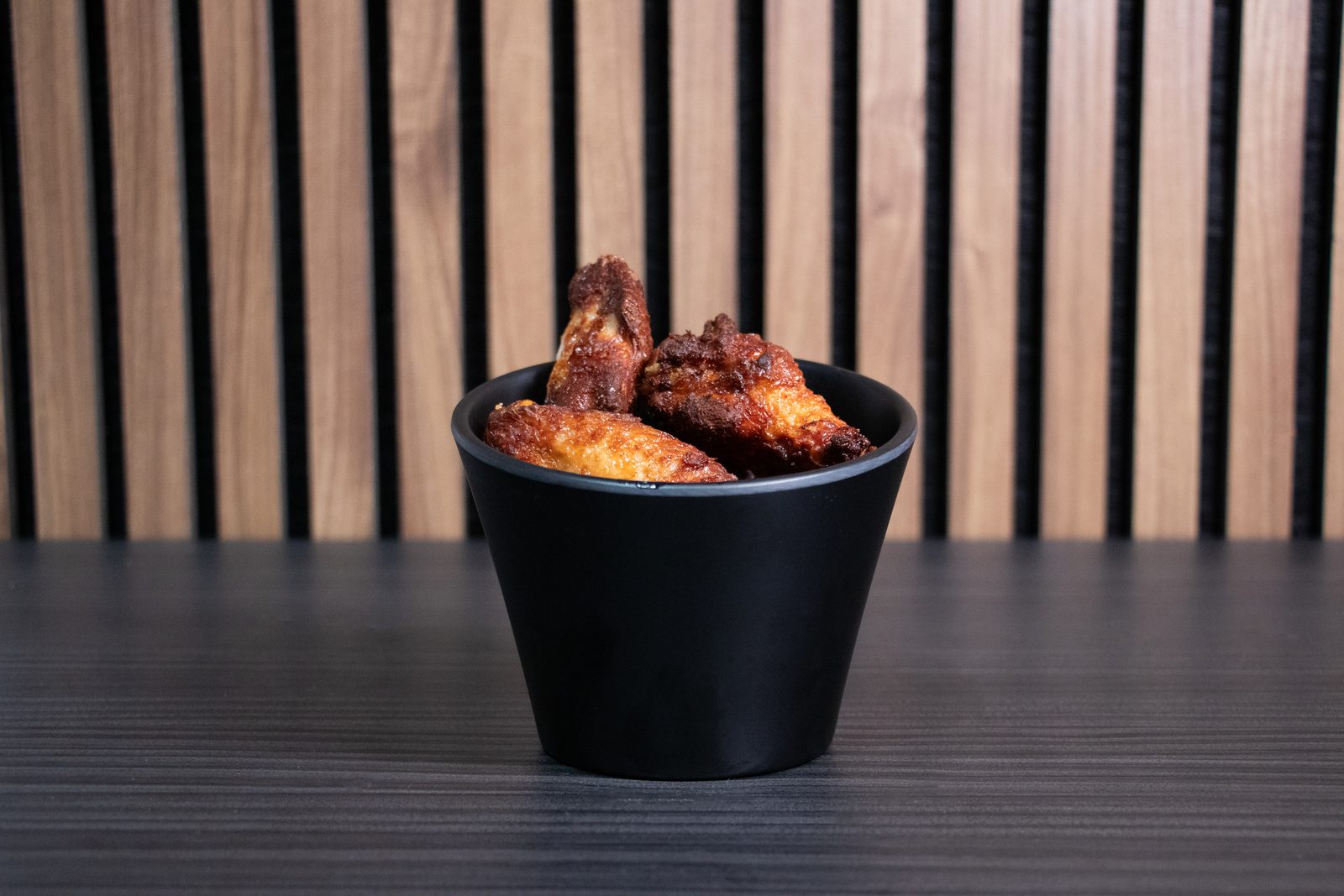 Chicken wings in a black cup