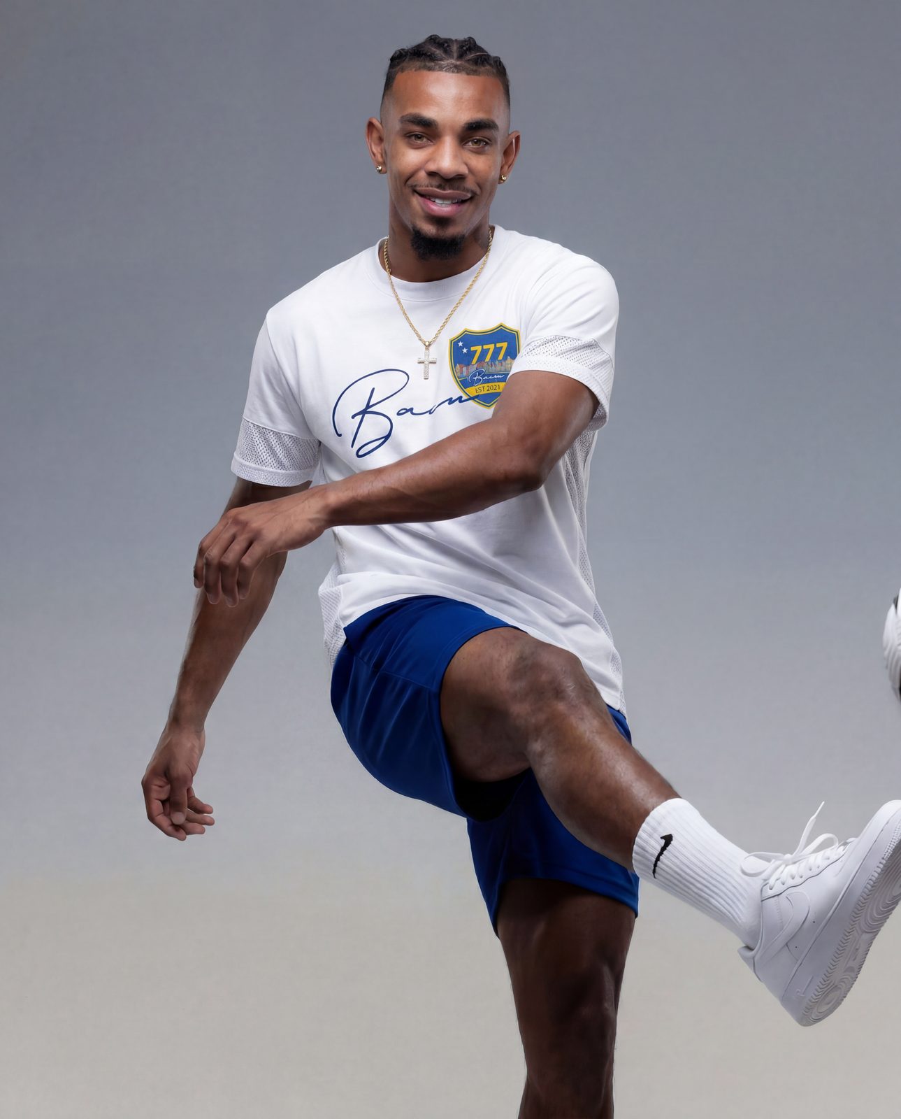 Model mid-kick in a white BACU tee and blue shorts