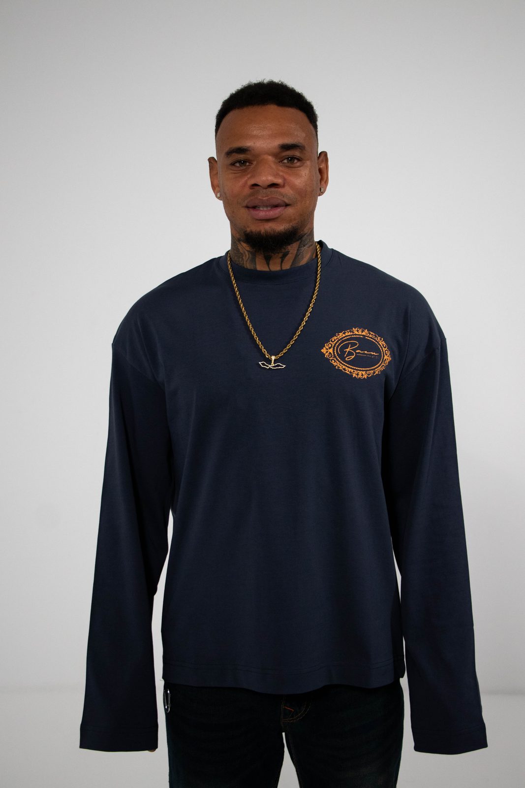 Model in a navy BACU longsleeve with an orange crest