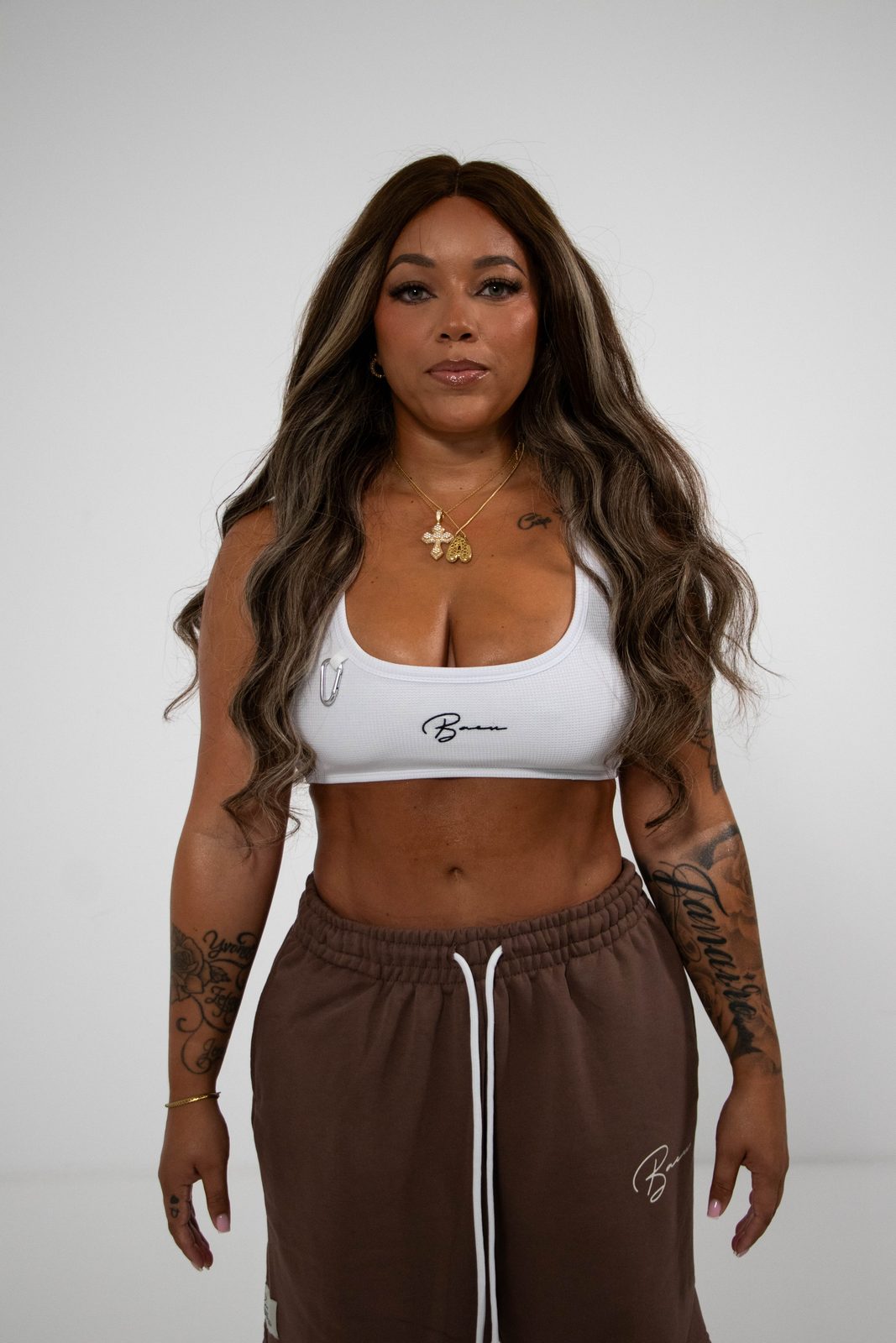 Model in a white BACU sports top and brown joggers