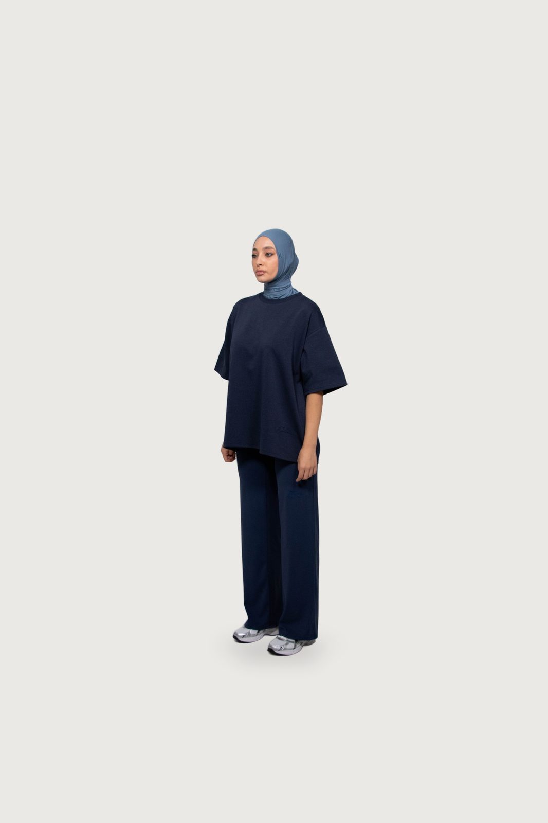 Model in a navy oversized tee and trousers with a blue hijab