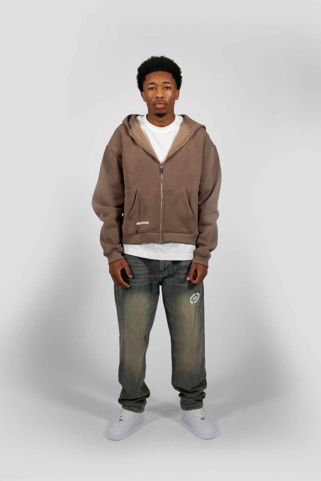 Model in a brown Mohina zip hoodie and washed jeans