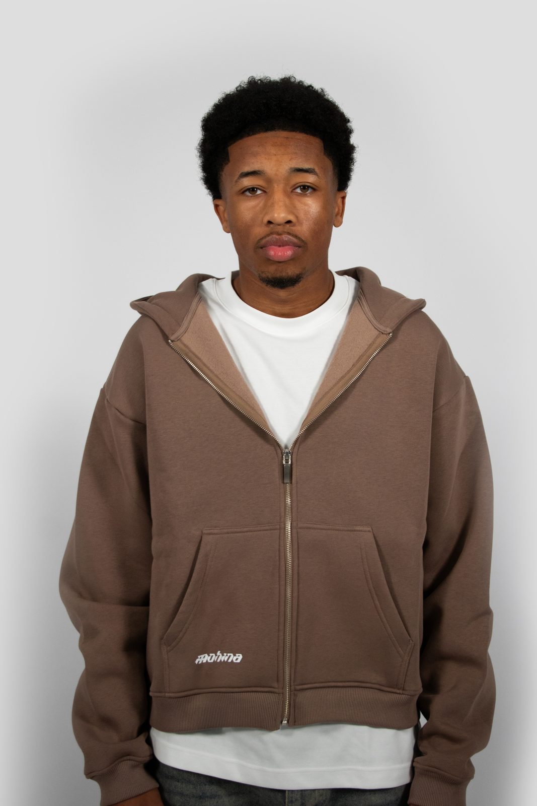 Model in a brown Mohina zip hoodie, waist up