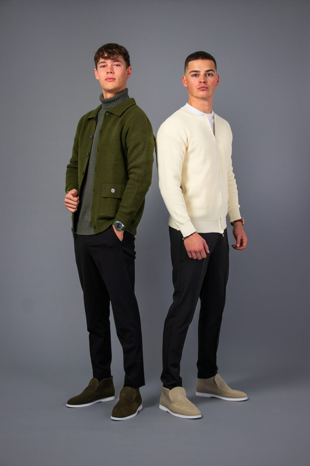 Two models in olive and cream NOBA knitwear on a grey backdrop