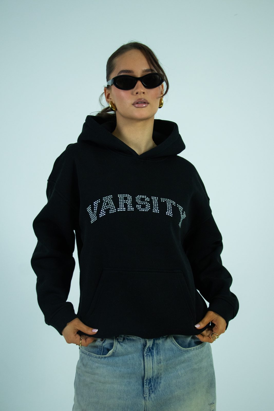 Model in sunglasses and a black Varsity hoodie