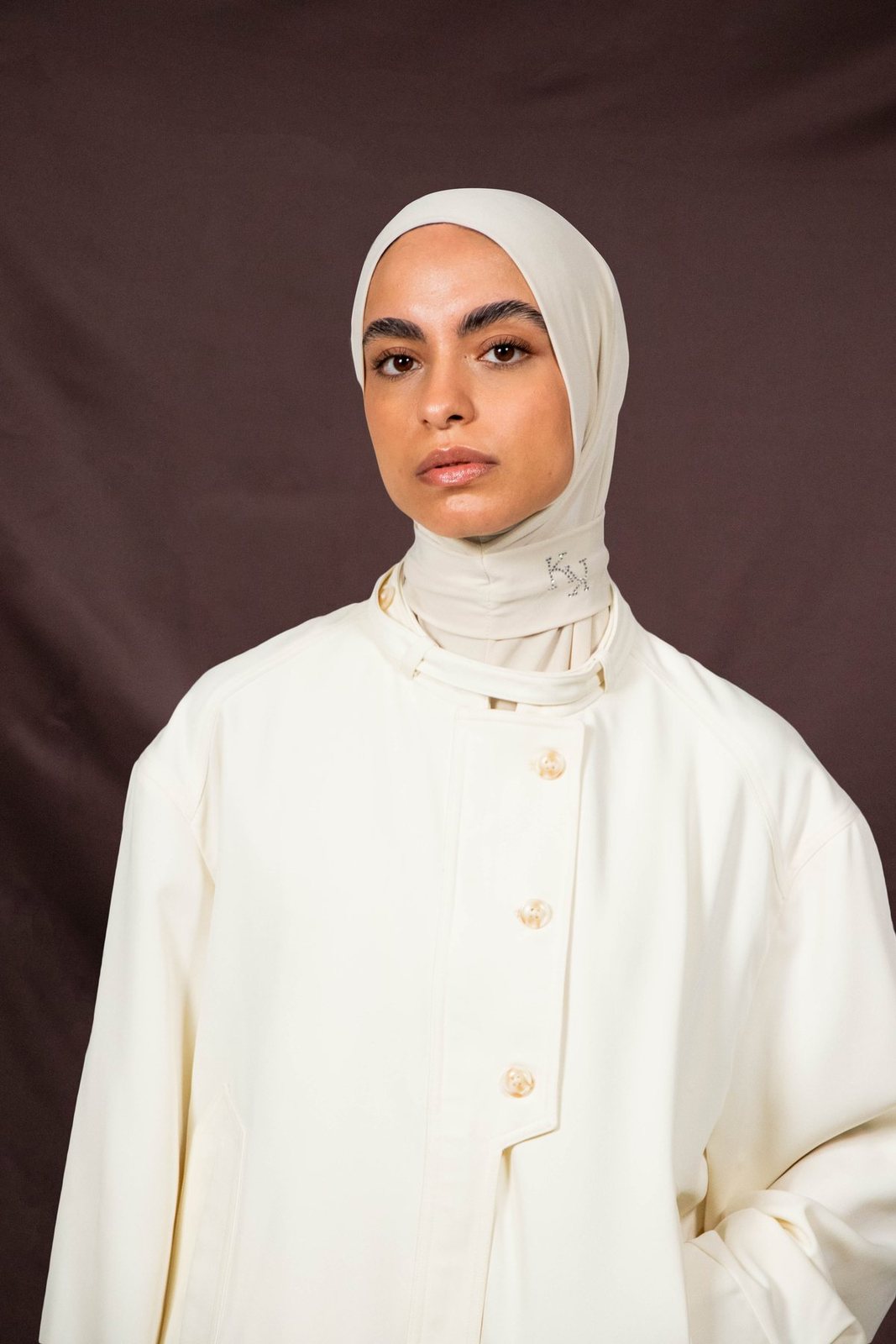 Model in an ivory hijab and ivory coat