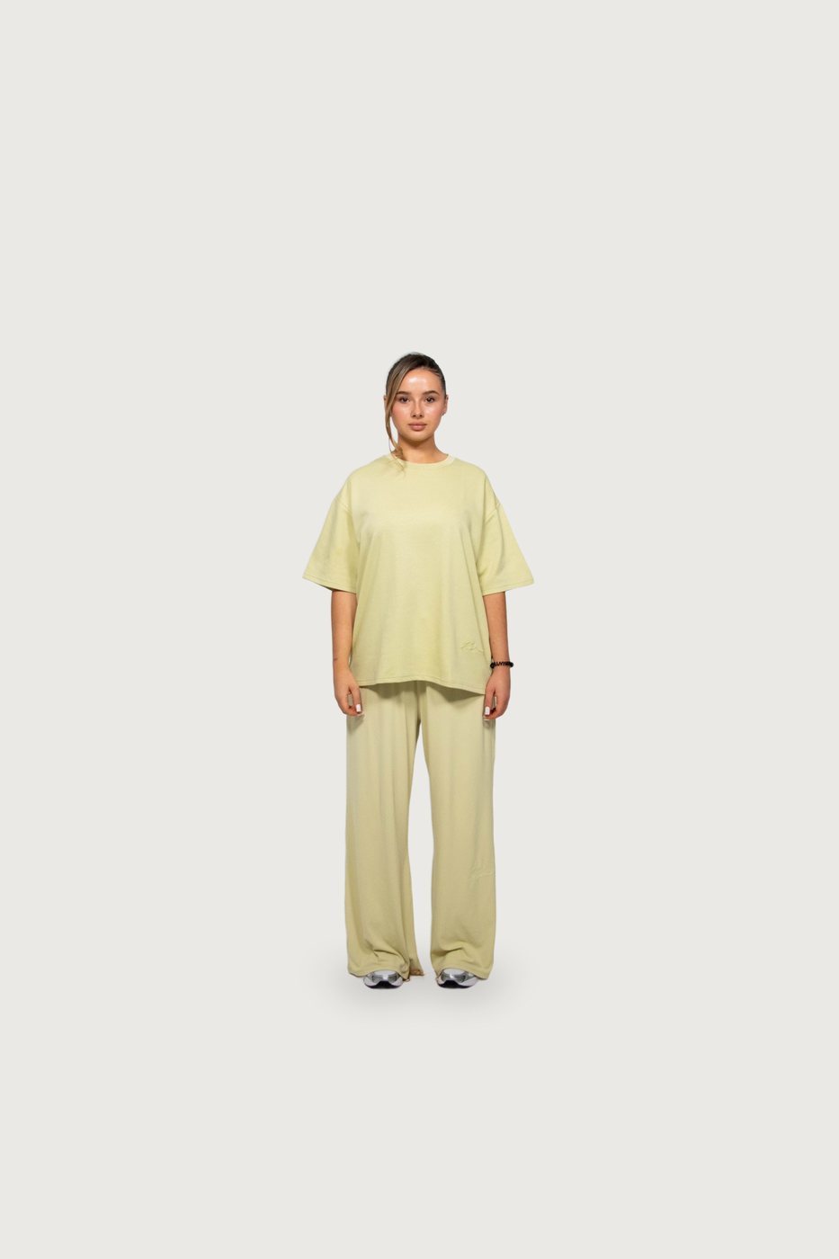 Model in a pale-yellow Kallouchi tee and wide trousers