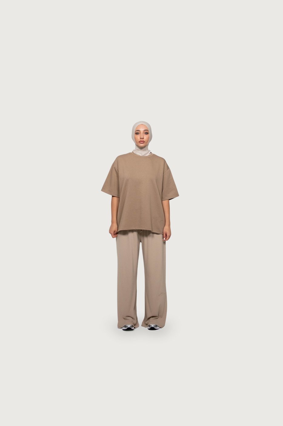 Model in a taupe tee and trousers with a cream hijab