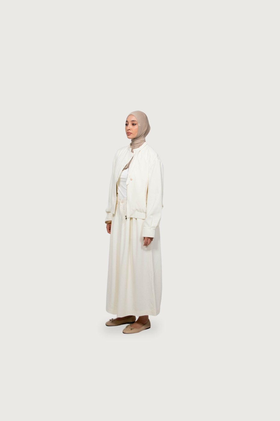 Model in an ivory jacket and long skirt