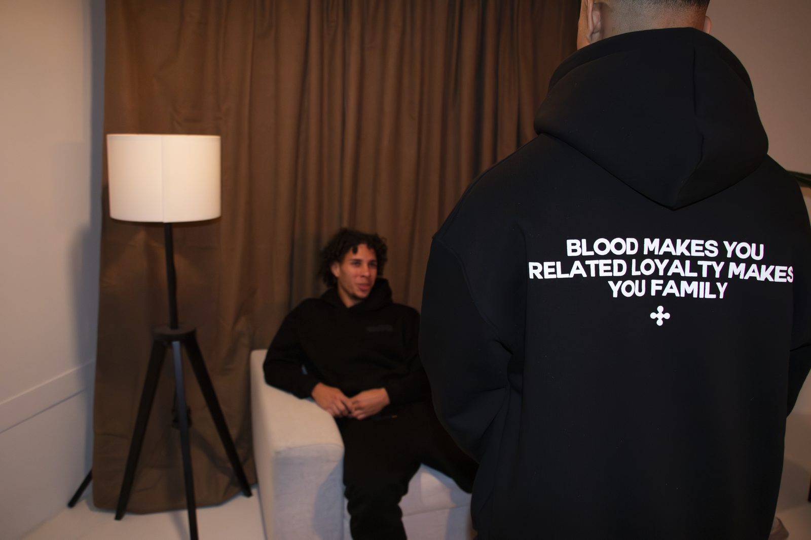 Back of a black LMF hoodie printed 'Blood makes you related, loyalty makes you family'