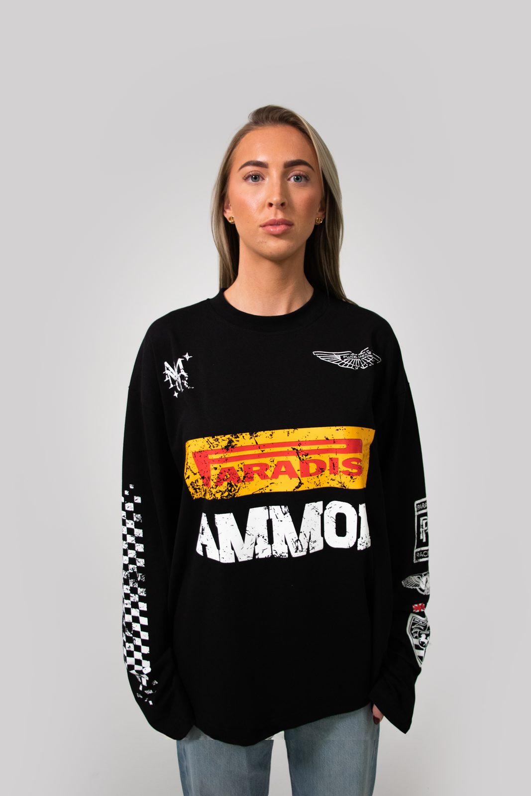 Model in a black Paradis Ammor racing longsleeve with chequered sleeves