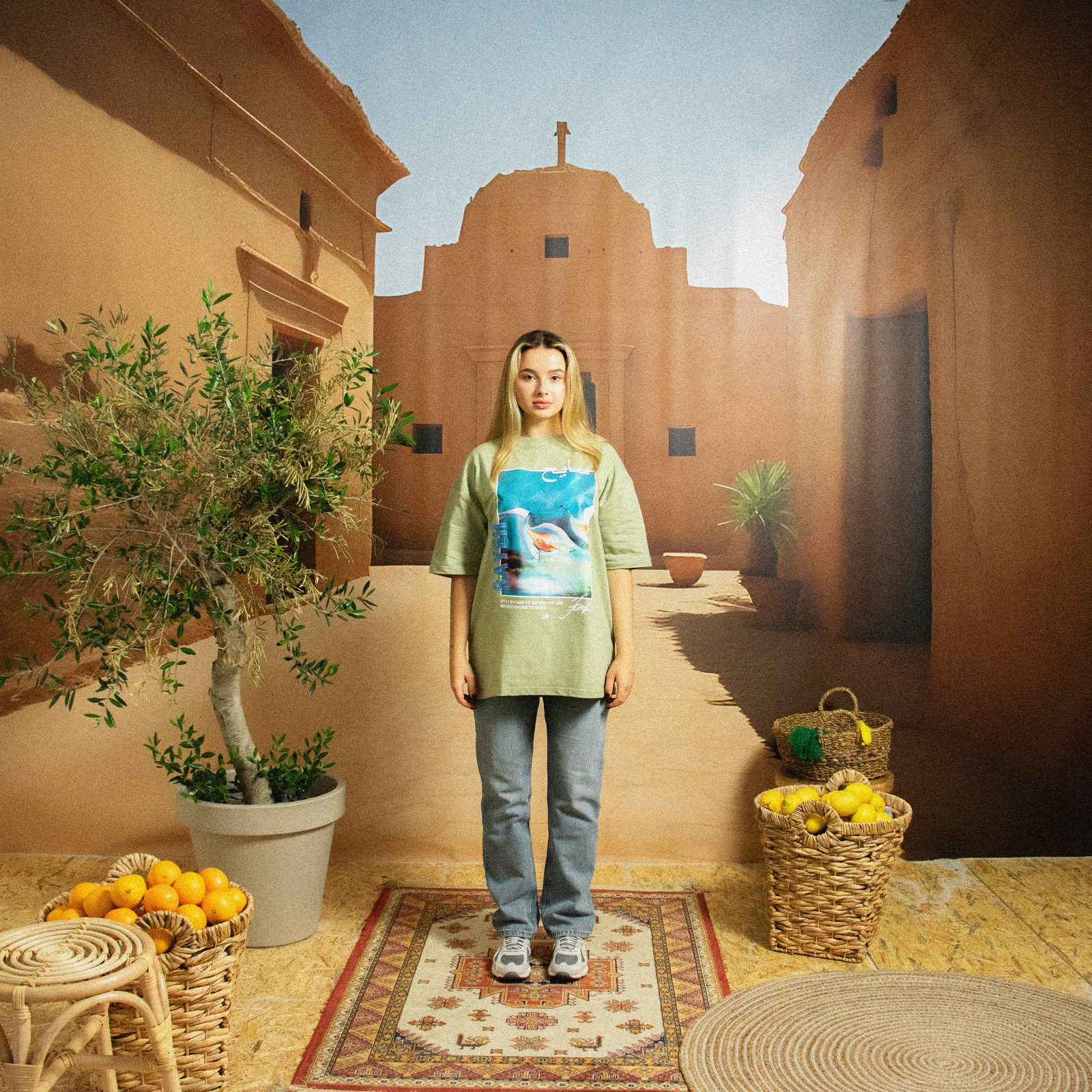 Model in a sage-green SAYEH tee on the Marrakech set