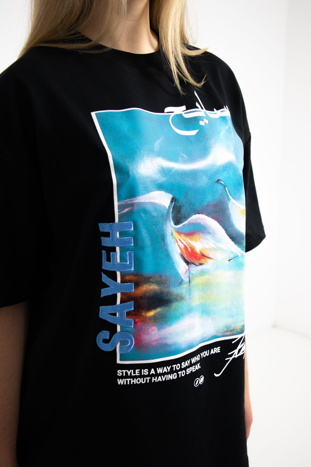 Close-up of the black SAYEH tee with its blue painted print