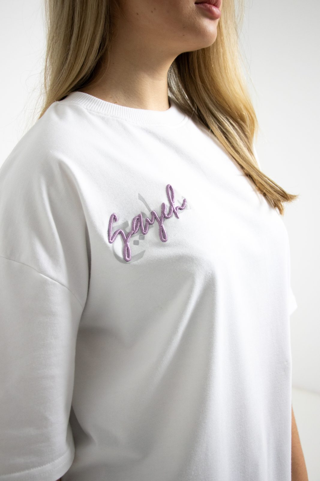 Close-up of the pink SAYEH script on a white tee