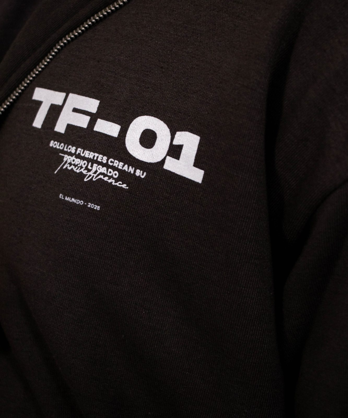 Close-up of a TF-01 back print on a dark hoodie