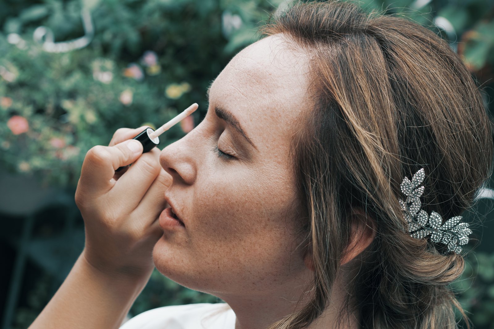 Close-up of Imre with her eyes closed while her make-up is applied