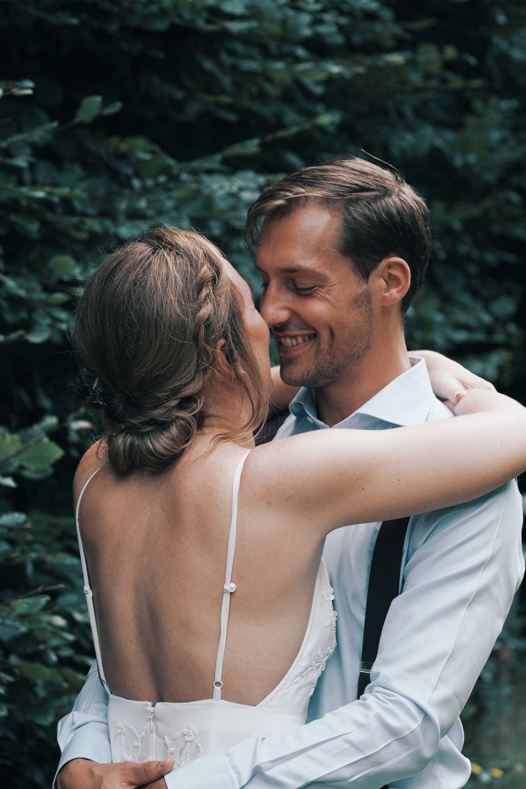 Imre with her arms around Chris, seen over her bare back, both smiling