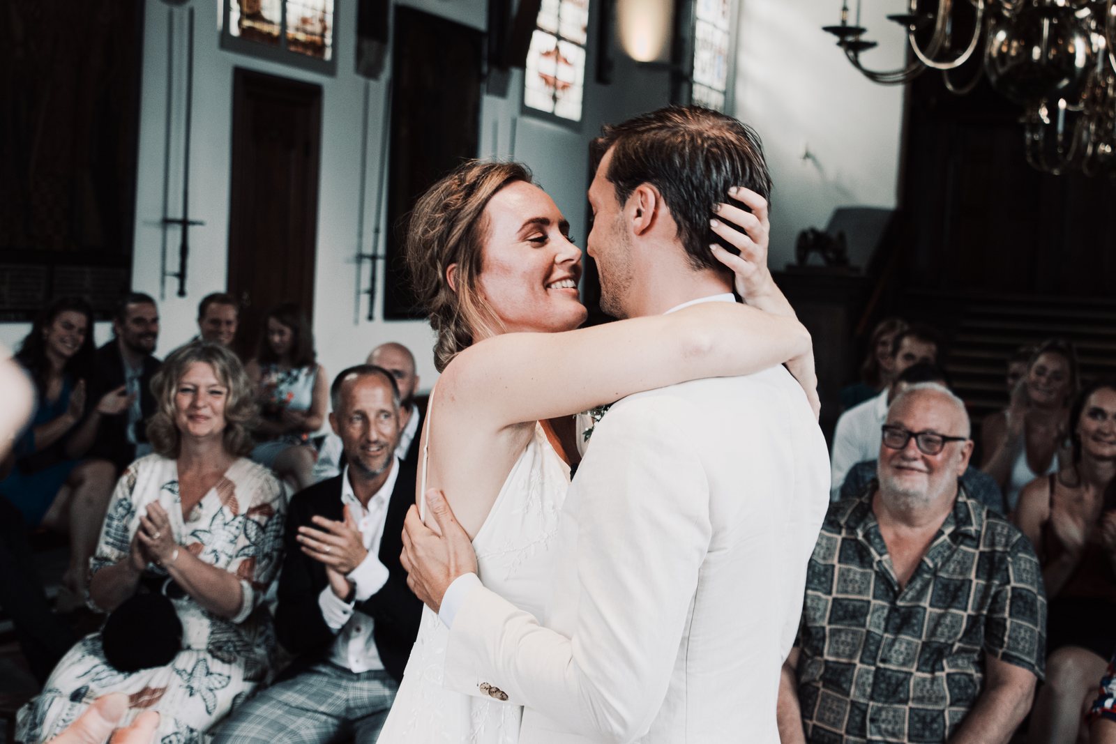 Imre and Chris embracing in front of their seated guests