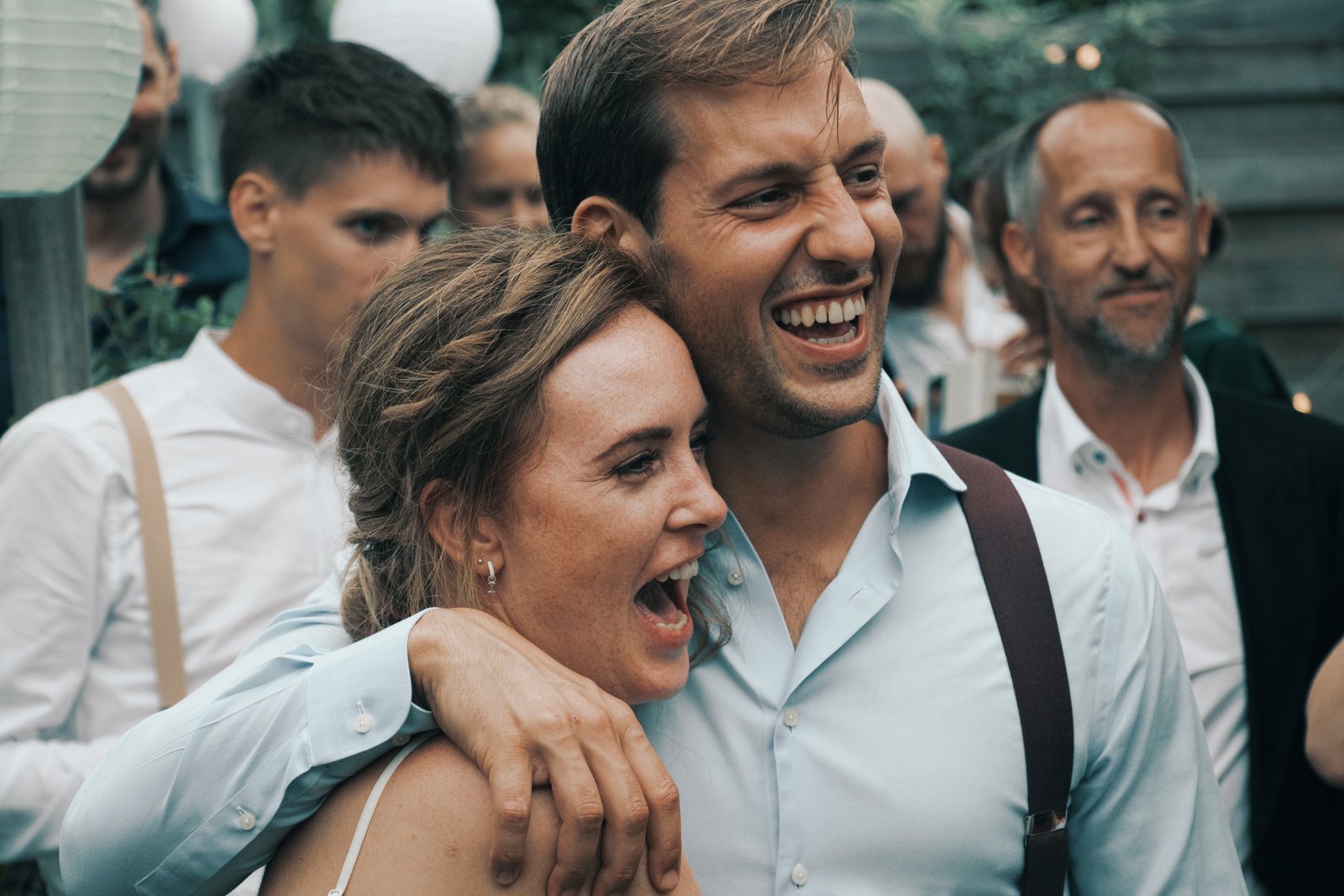 Chris and Imre laughing in a group hug with friends