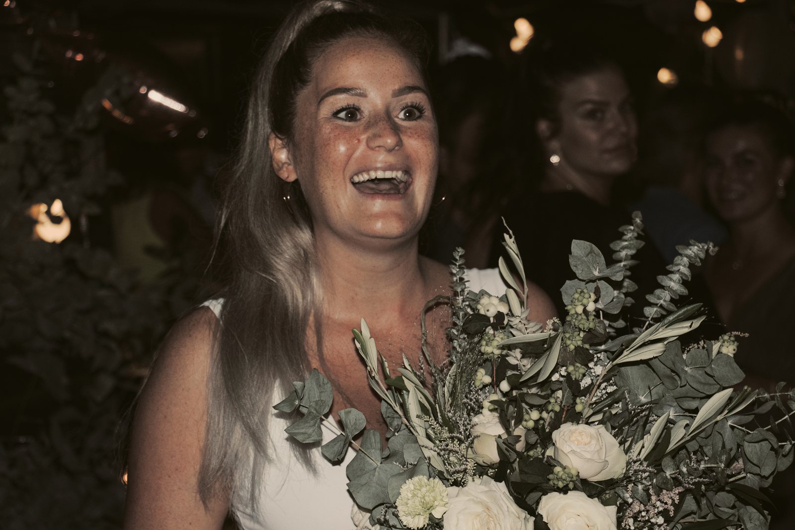 A guest beaming after catching the bouquet