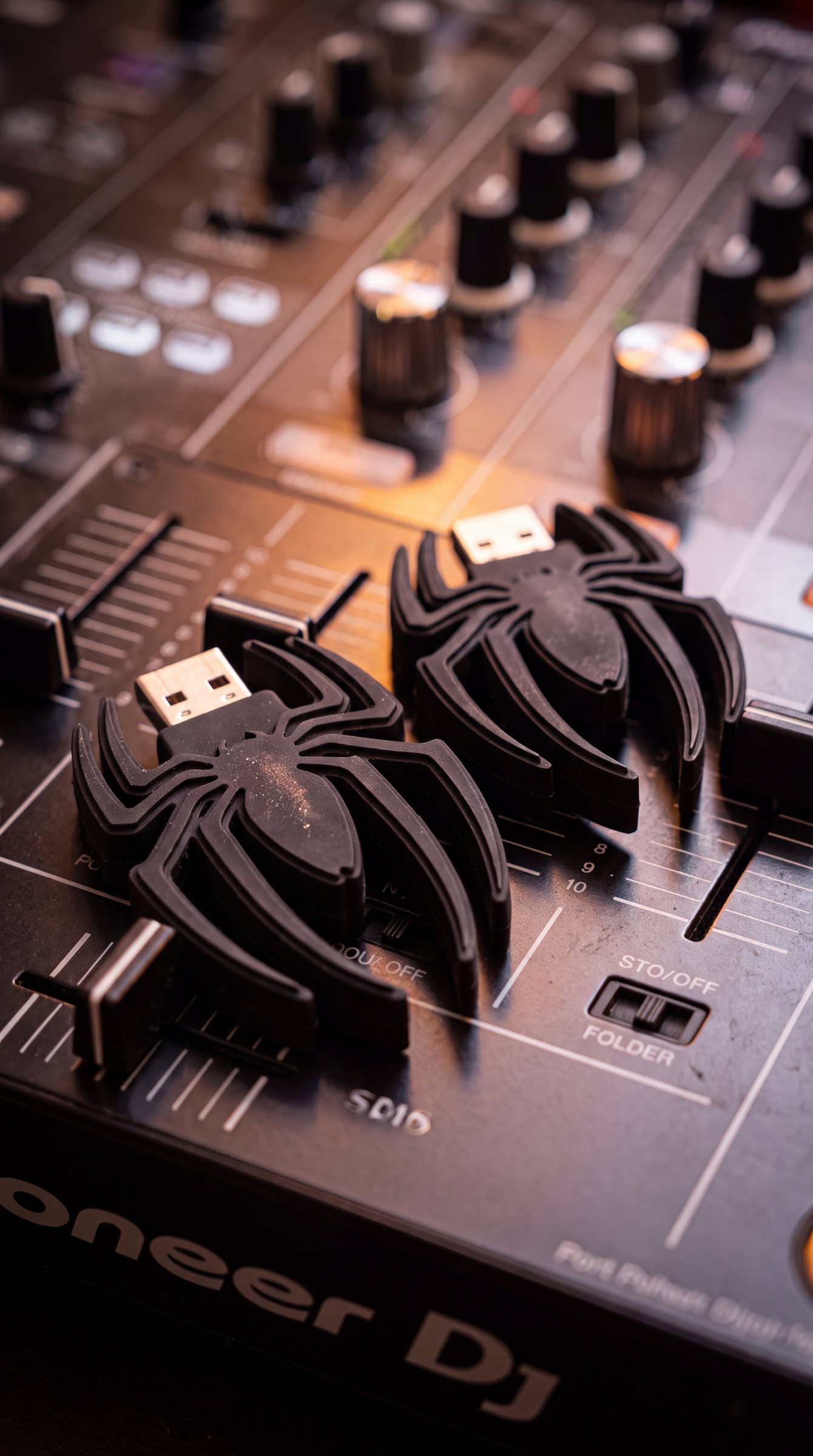 The first USBABY concept: two black spider-shaped USB sticks lying on a DJ mixer